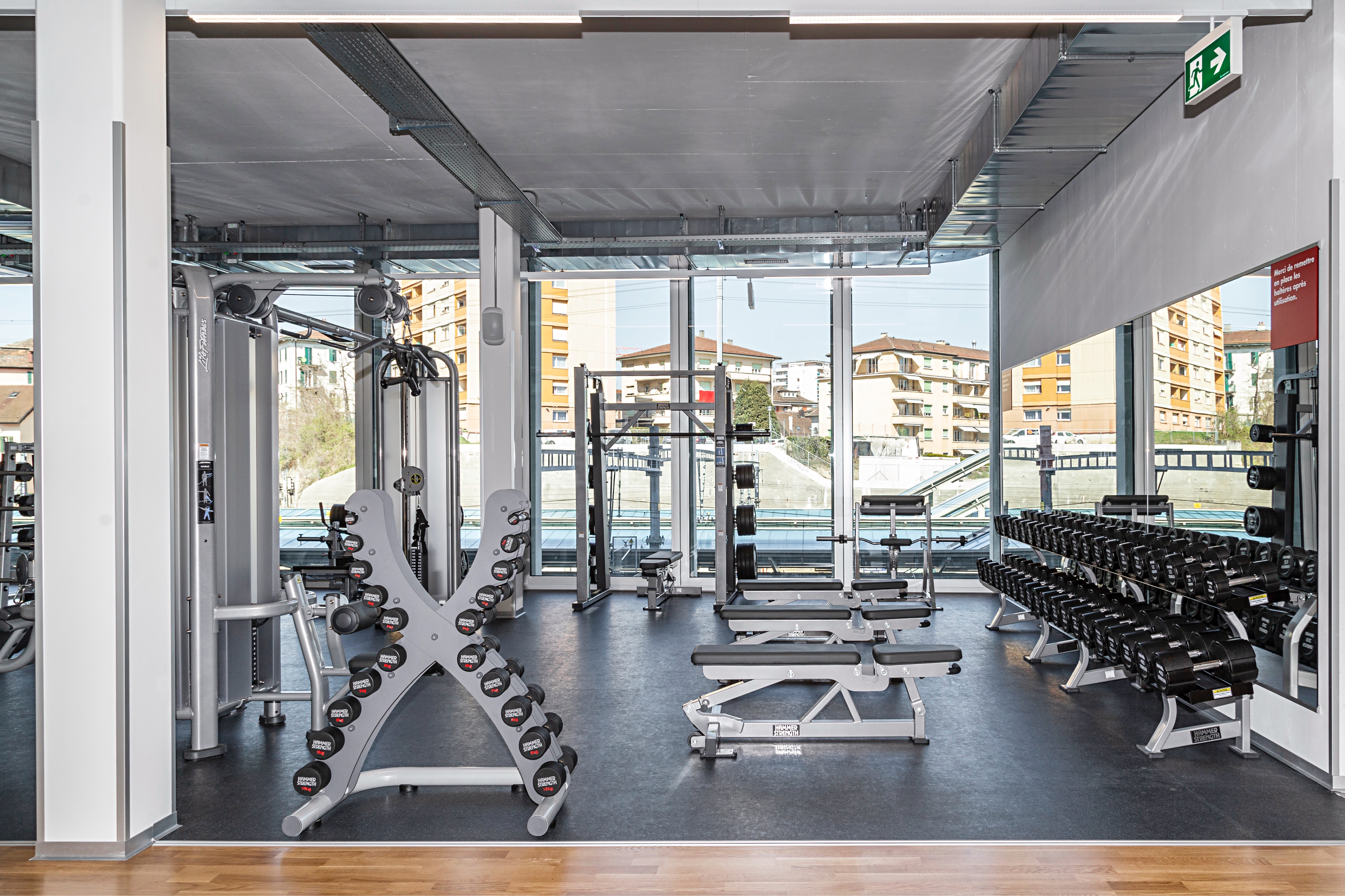 Area pesi liberi con manubri, bilancieri e rack per squat presso ACTIV FITNESS Renens